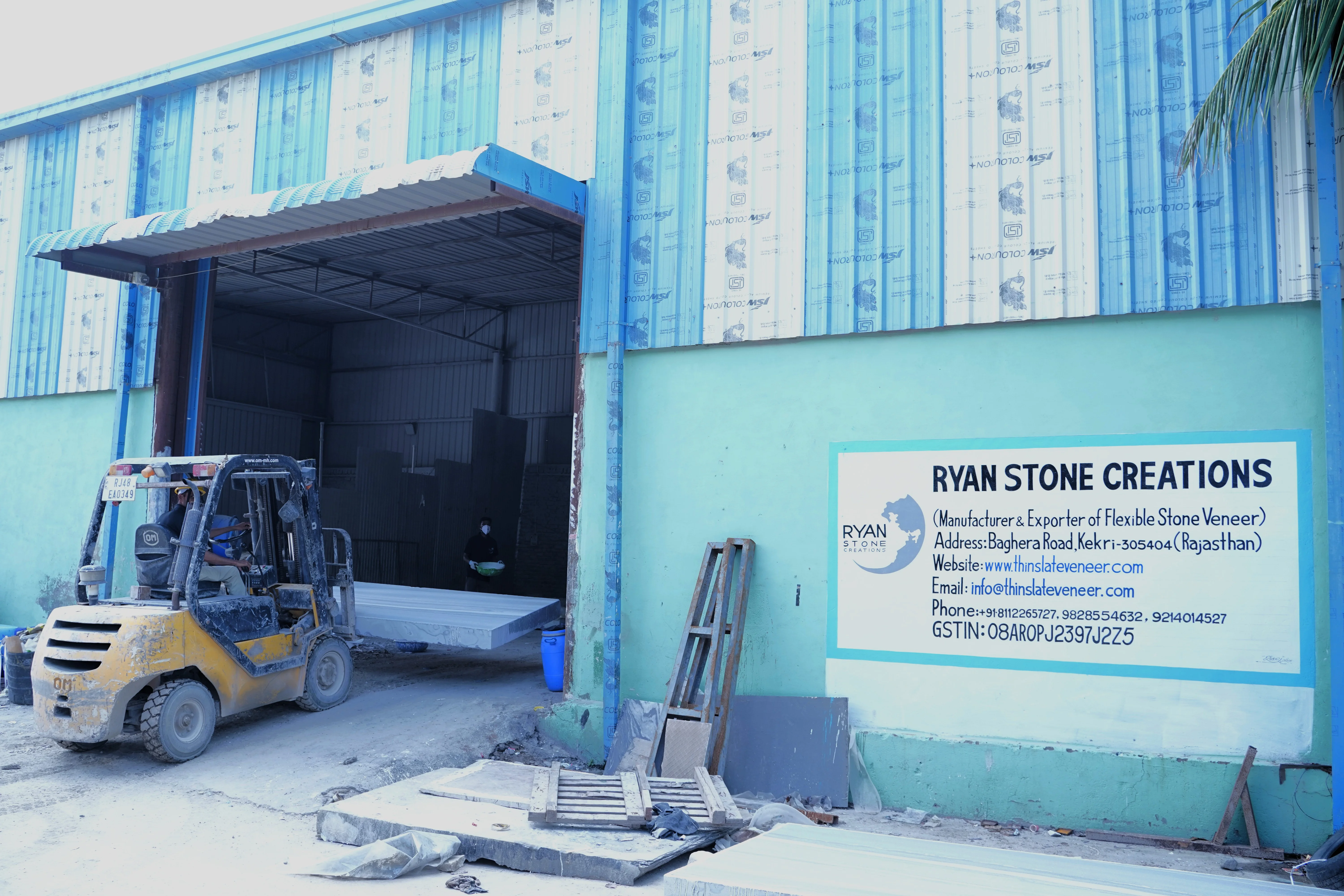 Manual peeling of natural flexible slate veneer sheet from raw stone block in factory